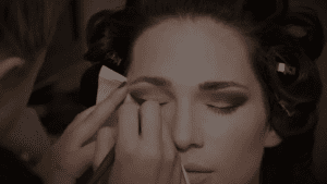 bride getting makeup for wedding by makeup artist